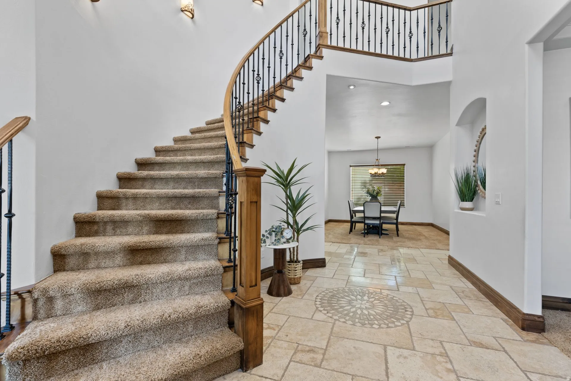 Stairway with a high ceiling, stone tile flooring, and recessed lighting
