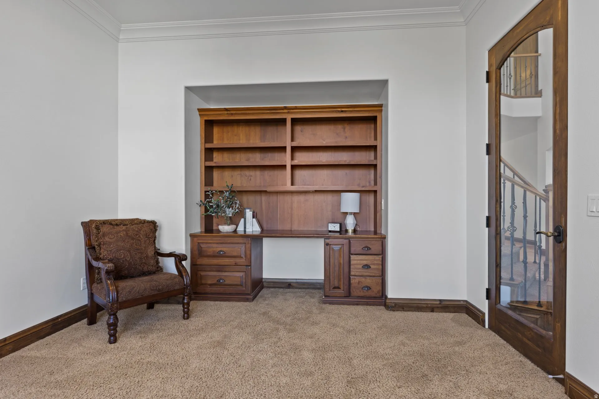 Sitting room with light colored carpet, ornamental molding, and a desk