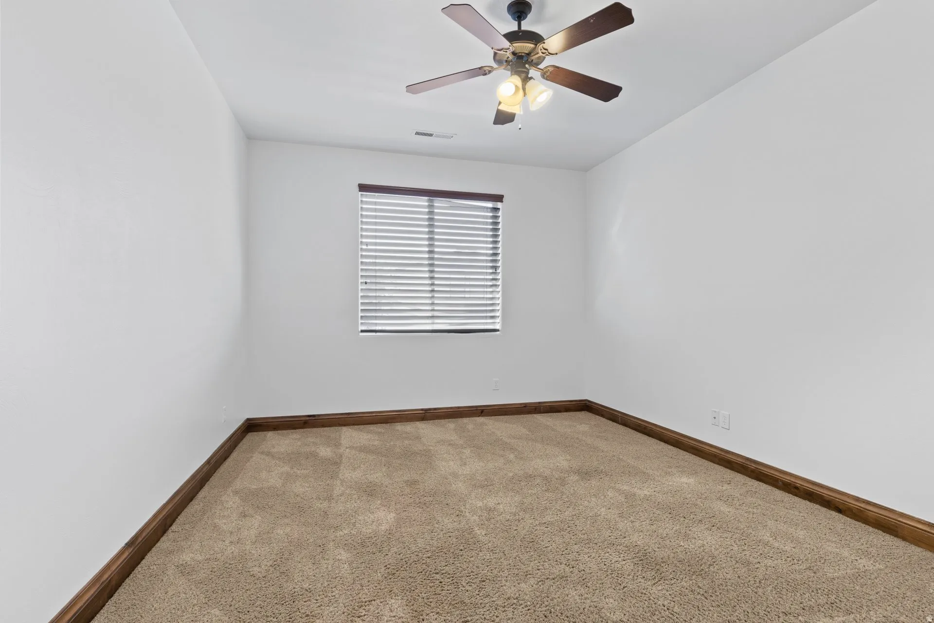 Unfurnished room with light carpet and a ceiling fan