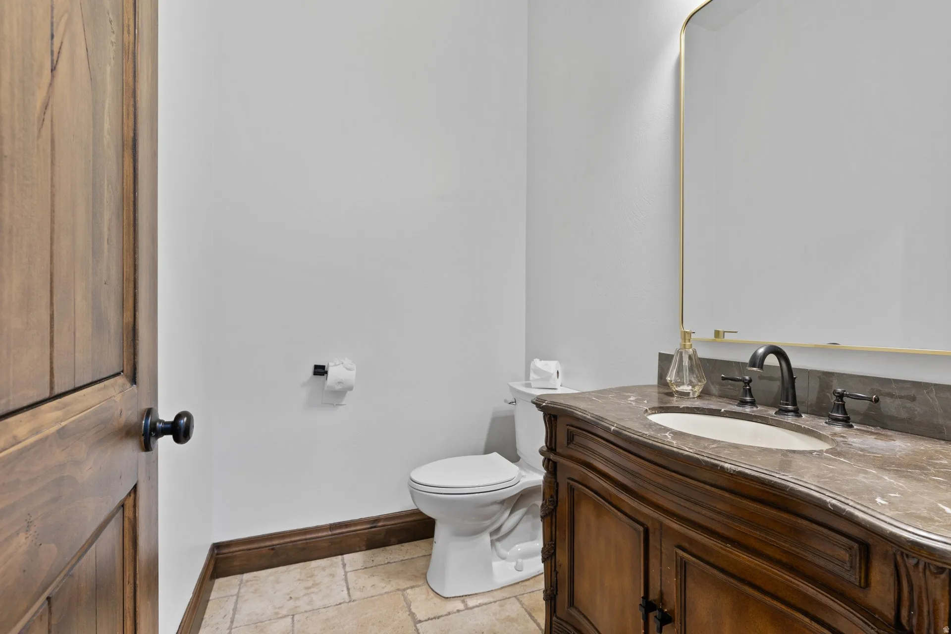 Half bath with vanity and stone tile floors