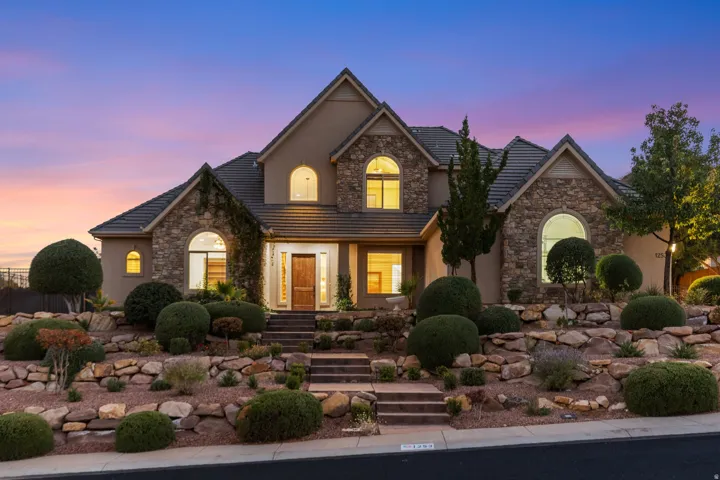 Traditional-style house featuring stone siding, stucco siding, and a tile roof