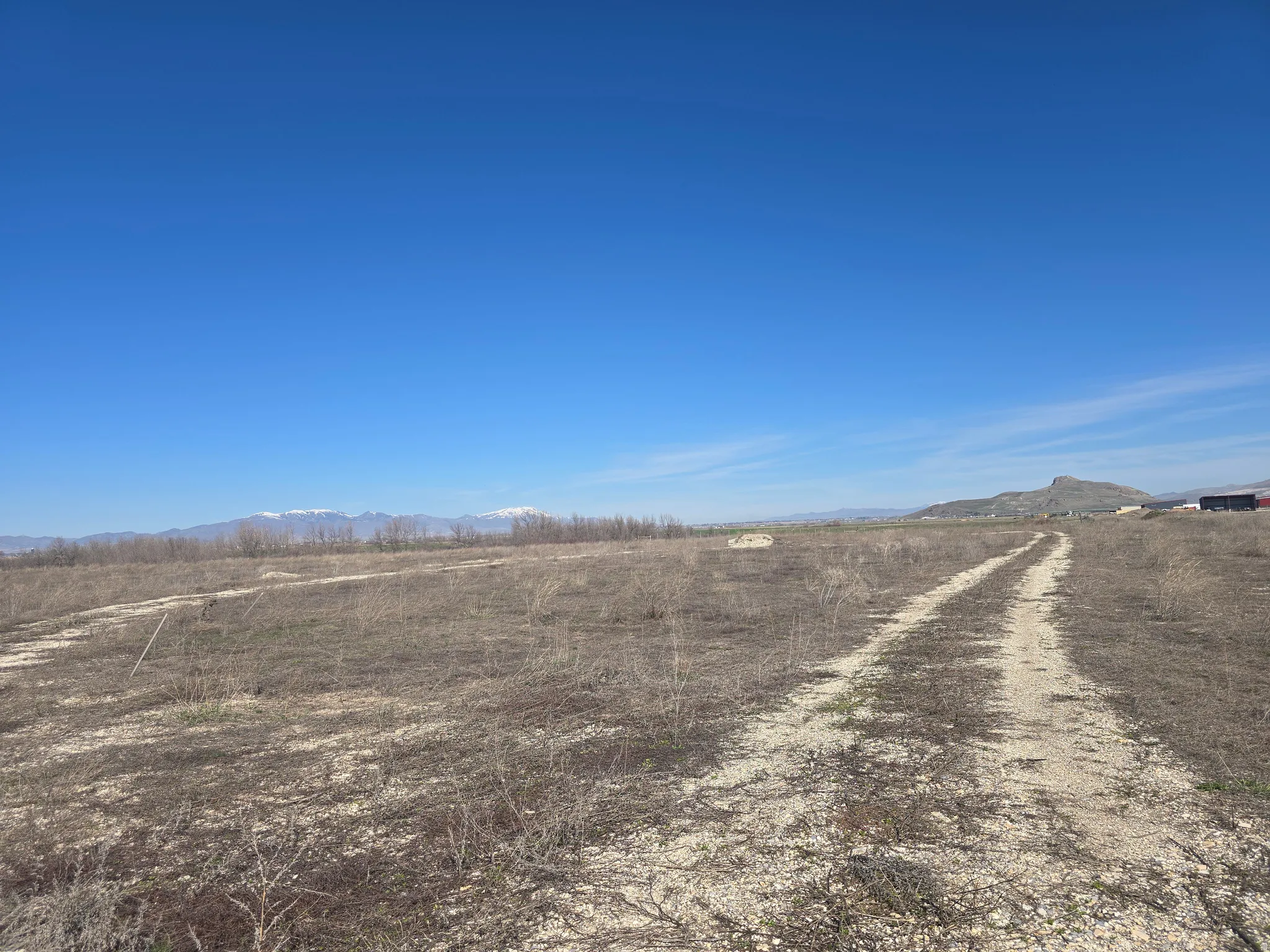 View of dirt / gravel road featuring a rural view and a mountain view