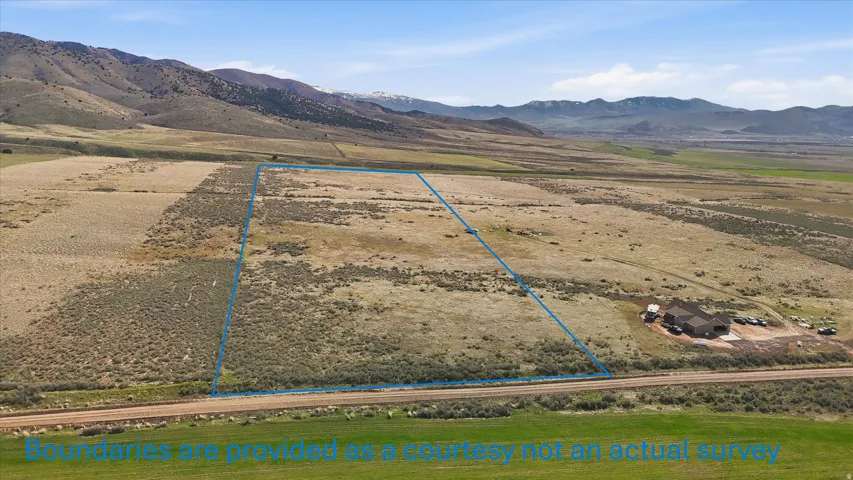 Aerial view of sparsely populated area with a mountain backdrop and property parcel outlined