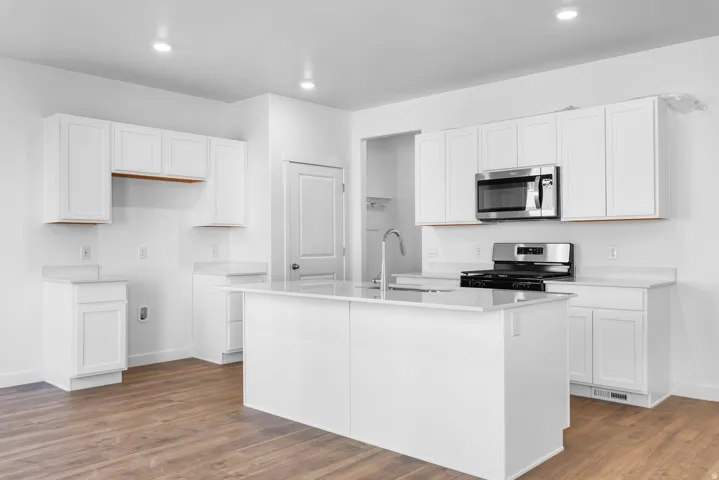 Kitchen with white cabinetry, an island with sink, stainless steel appliances, dark wood-style floors, and recessed lighting