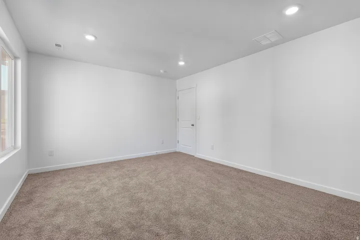 Empty room with carpet flooring and recessed lighting