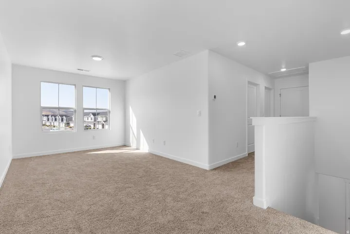 Spare room with light carpet and baseboards