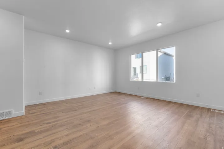 Empty room with wood finished floors and recessed lighting