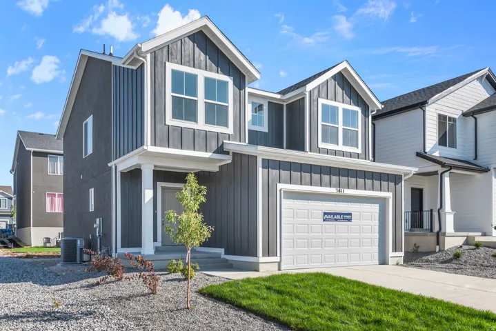 View of front of home featuring board and batten siding, an attached garage, and driveway