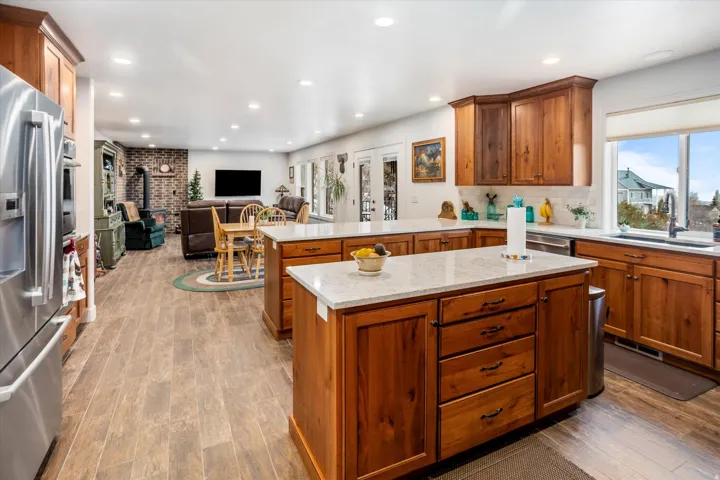 Kitchen with open floor plan, stainless steel appliances, a peninsula, dark wood-type flooring, and wood finish cabinetry