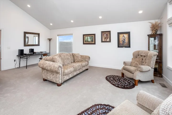 Living area with carpet flooring, recessed lighting, an office area, and lofted ceiling