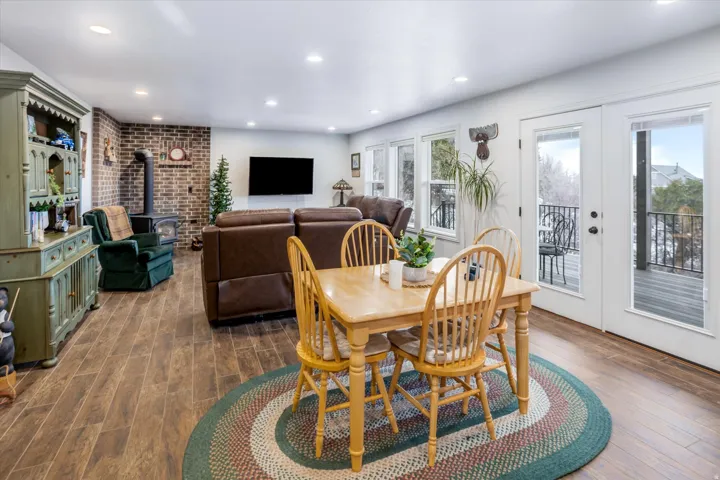 Dining space featuring wood finished floors, french doors, recessed lighting, a wood stove, and brick wall