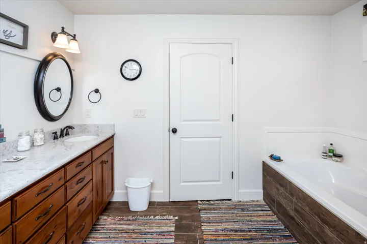 Full bath featuring vanity, dark wood-style floors, and a bath