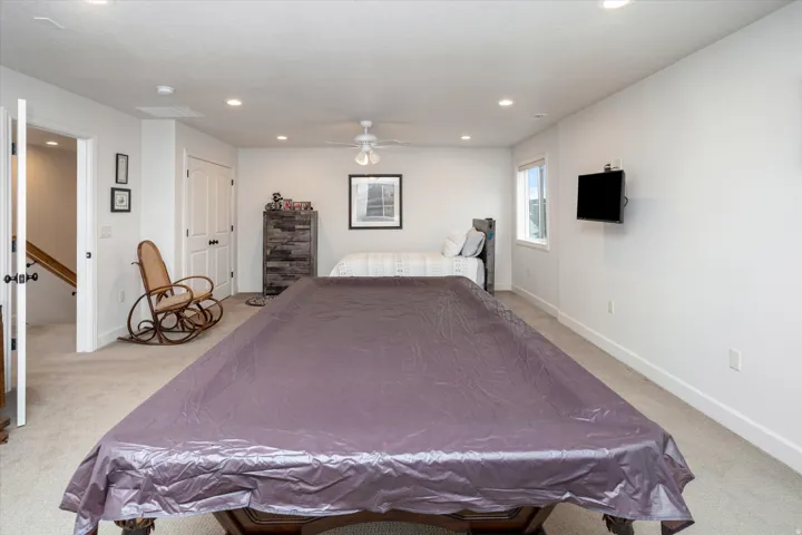 Bedroom with light carpet, a ceiling fan, and recessed lighting