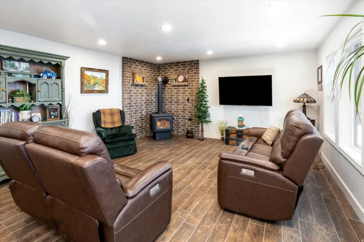 Living area featuring wood tiled floors, a wood stove, and recessed lighting