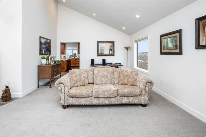 Carpeted living area featuring vaulted ceiling, healthy amount of natural light, recessed lighting, and an office area