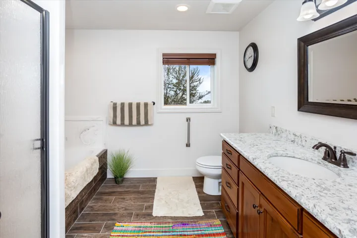 Full bath with vanity, wood finish floors, a bath, recessed lighting, and a stall shower