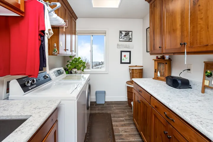 Laundry room with wood finish floors, independent washer and dryer, and cabinet space