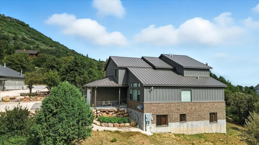 View of side of property featuring brick siding and a metal roof