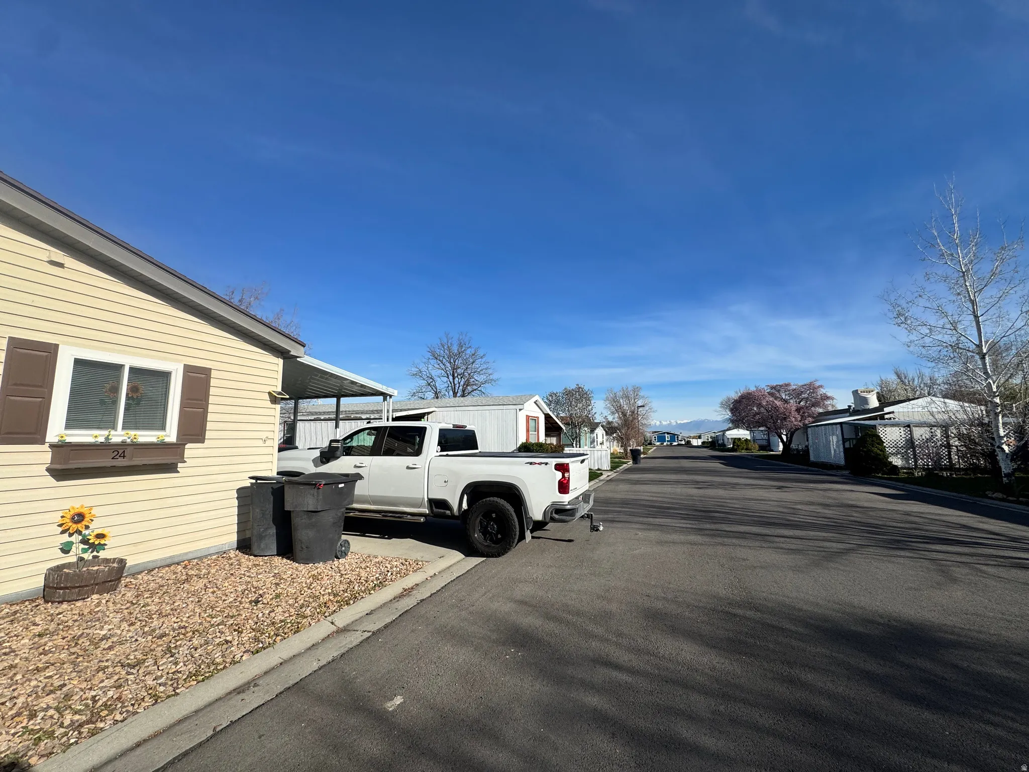 View of asphalt road with a residential view and curbs