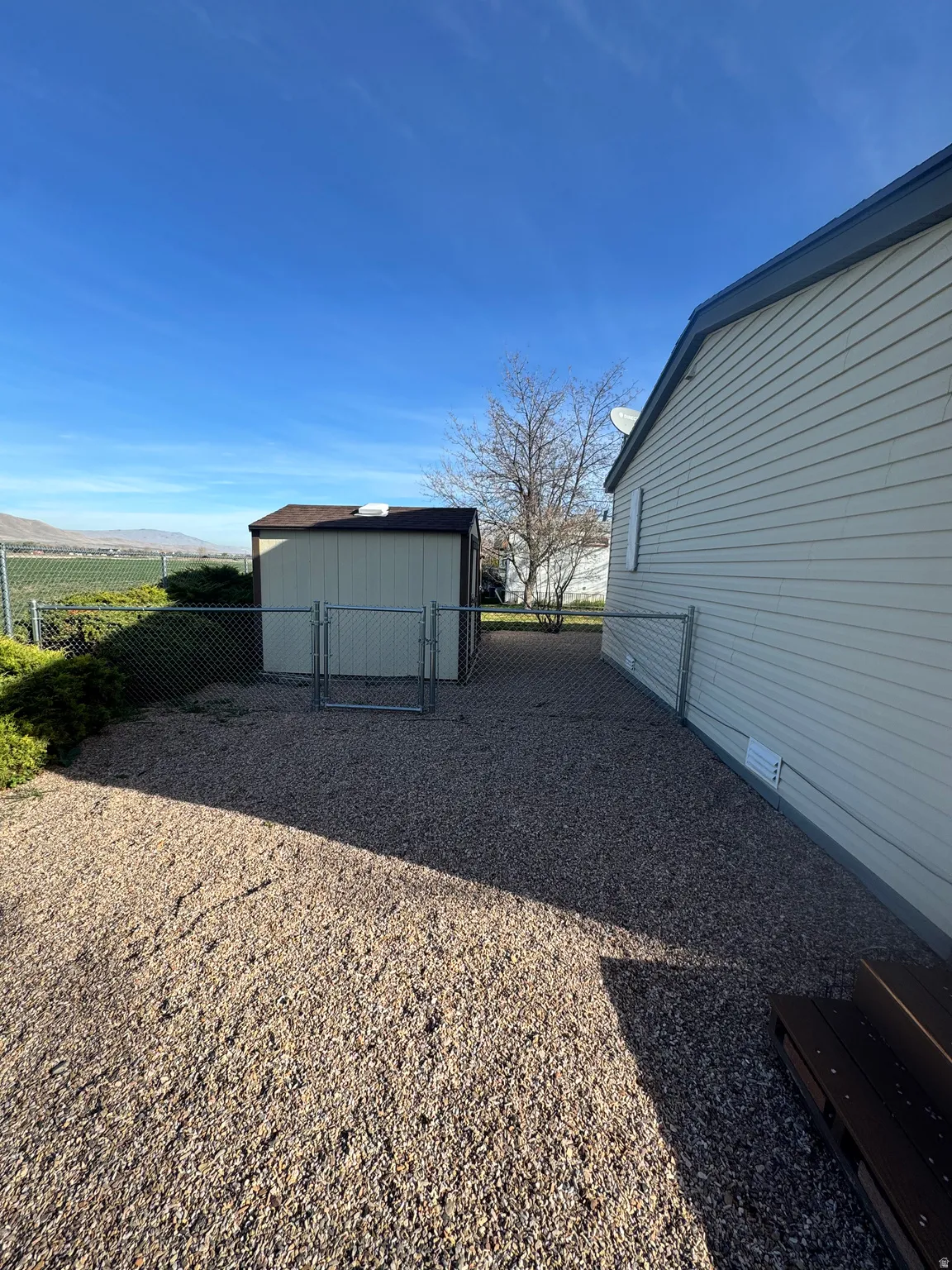 View of yard featuring a gate, an outbuilding, and a mountain view