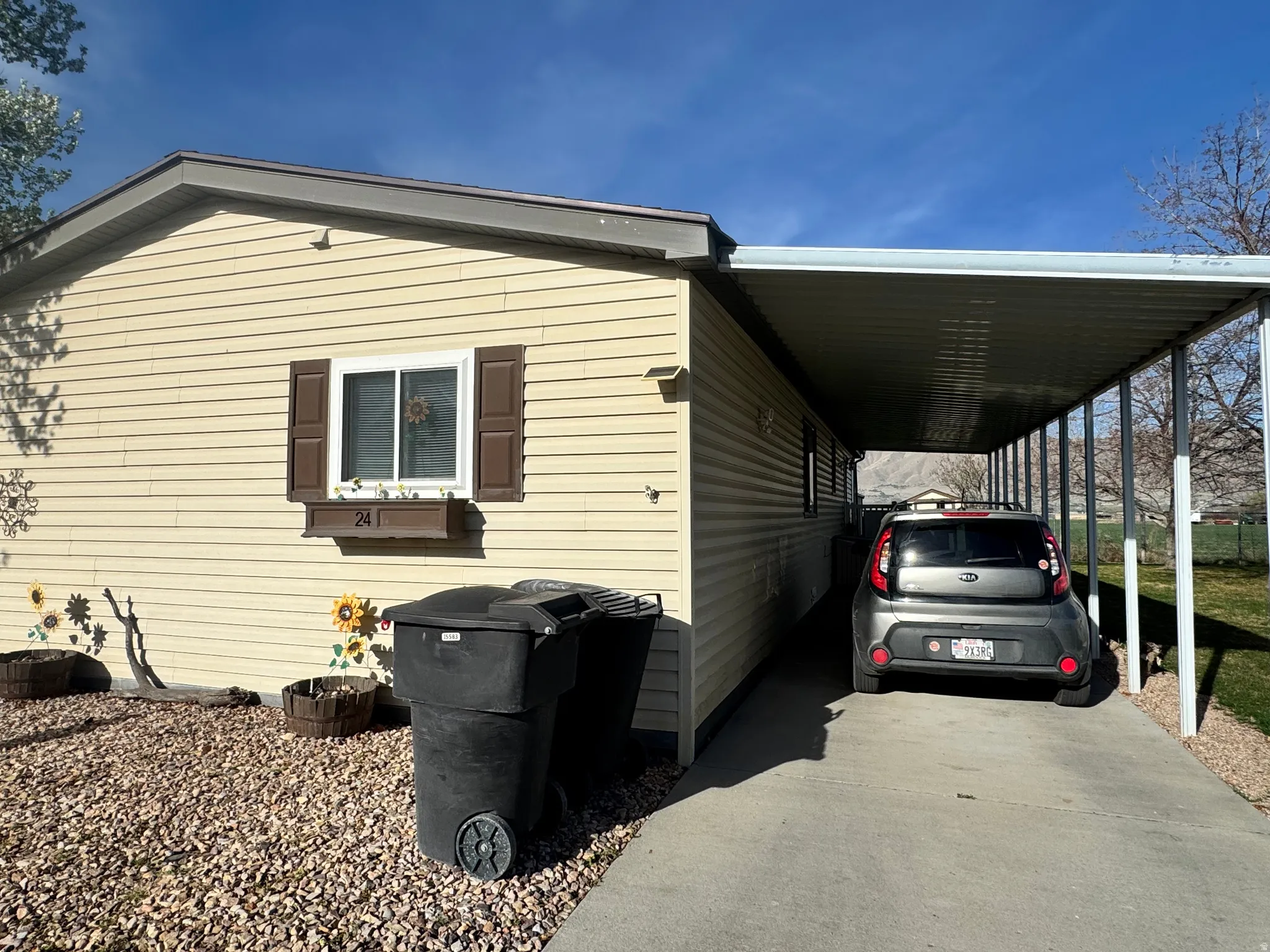 View of side of property featuring a carport and driveway