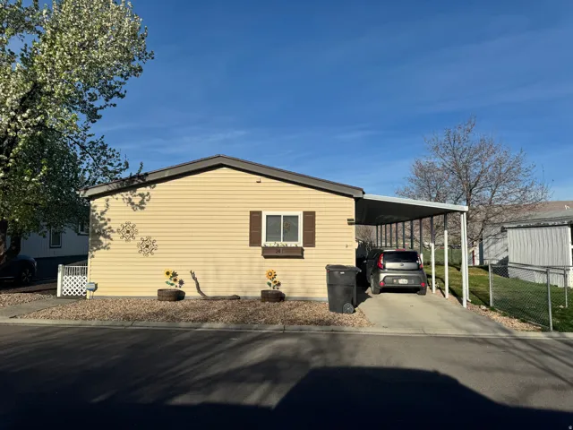 View of property exterior with an attached carport and concrete driveway