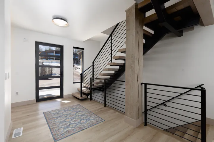 Entrance foyer with stairs going up and going down and light wood-style flooring
