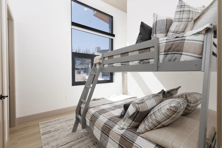 Bedroom featuring en-suite bathroom, and light wood-type flooring