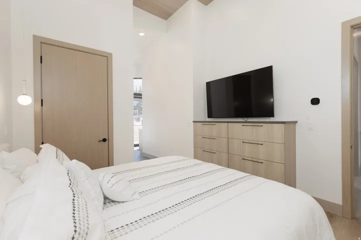 Primary bedroom with recessed lighting, wood finished floors, built-in dressers and a high wood ceiling
