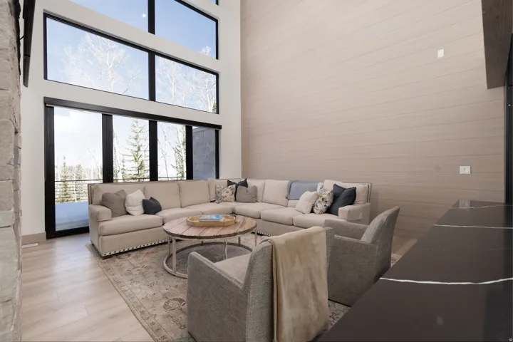 Living room featuring healthy amount of natural light, a high ceiling, and wood finished floors