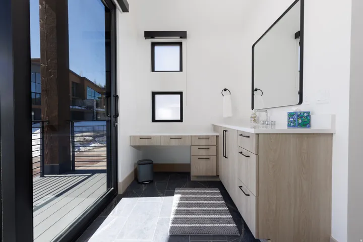 Primary bathroom with vanity and baseboards
