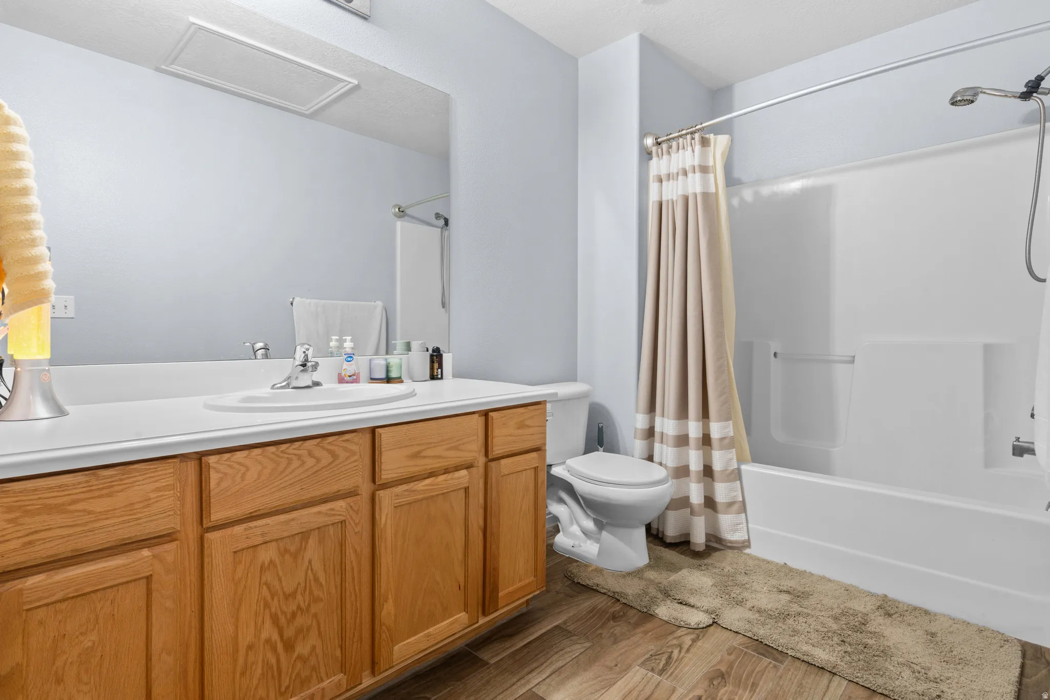 Full bathroom featuring vanity, light wood-style flooring, and shower / tub combo with curtain