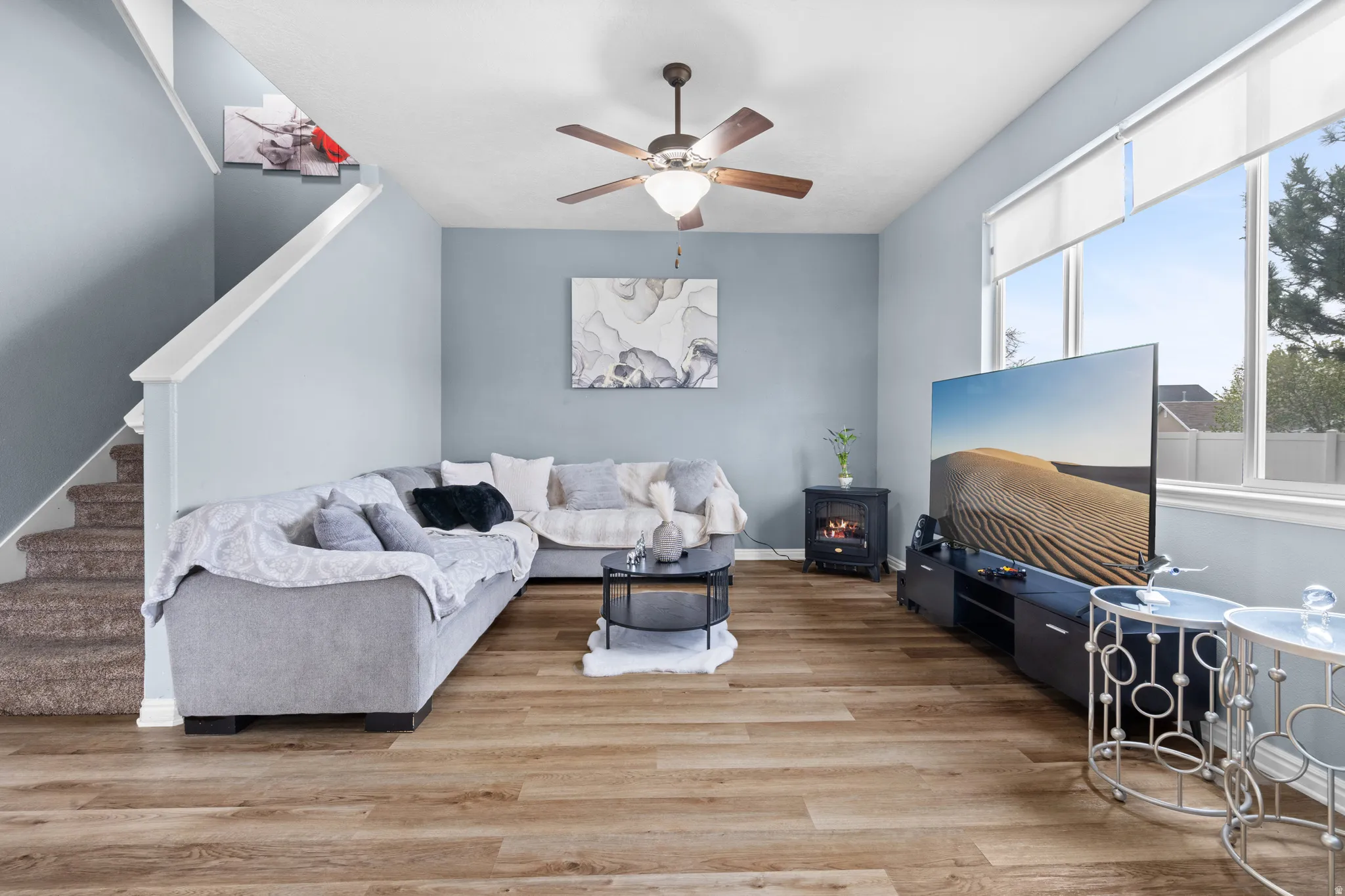 Living area featuring ceiling fan and light wood-style floors