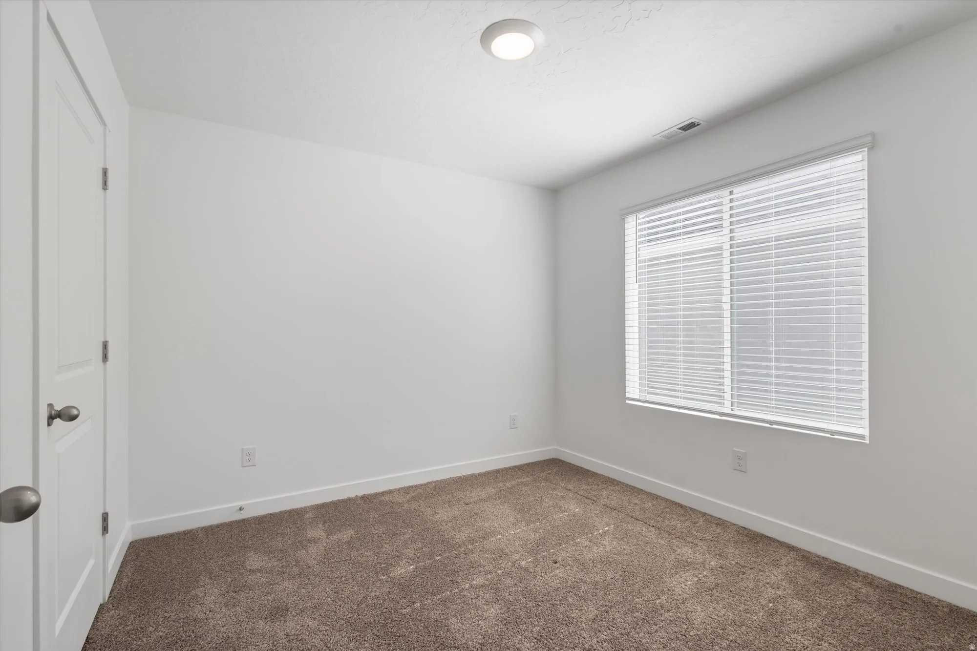 Unfurnished room with baseboards and dark colored carpet