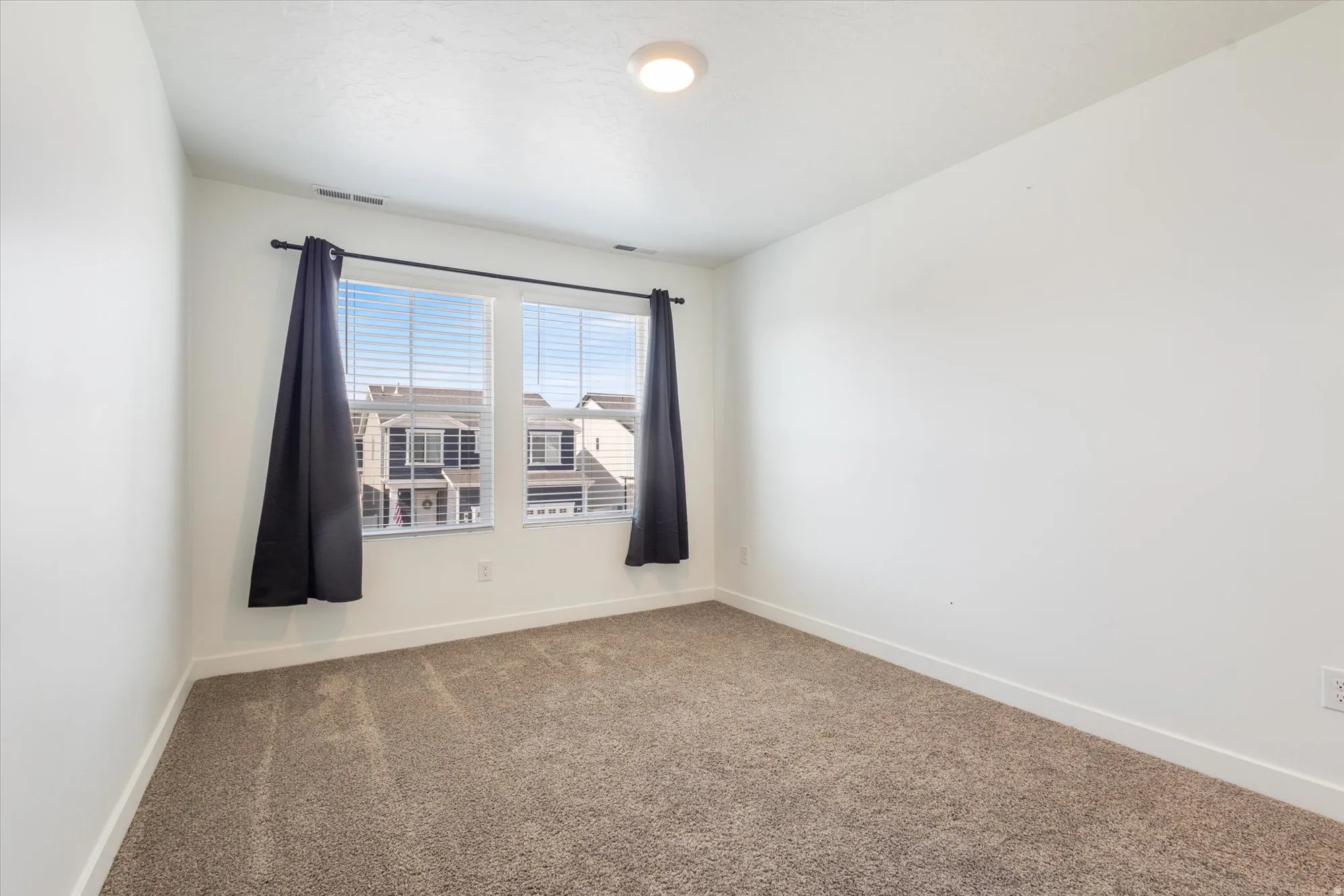 Carpeted empty room with baseboards