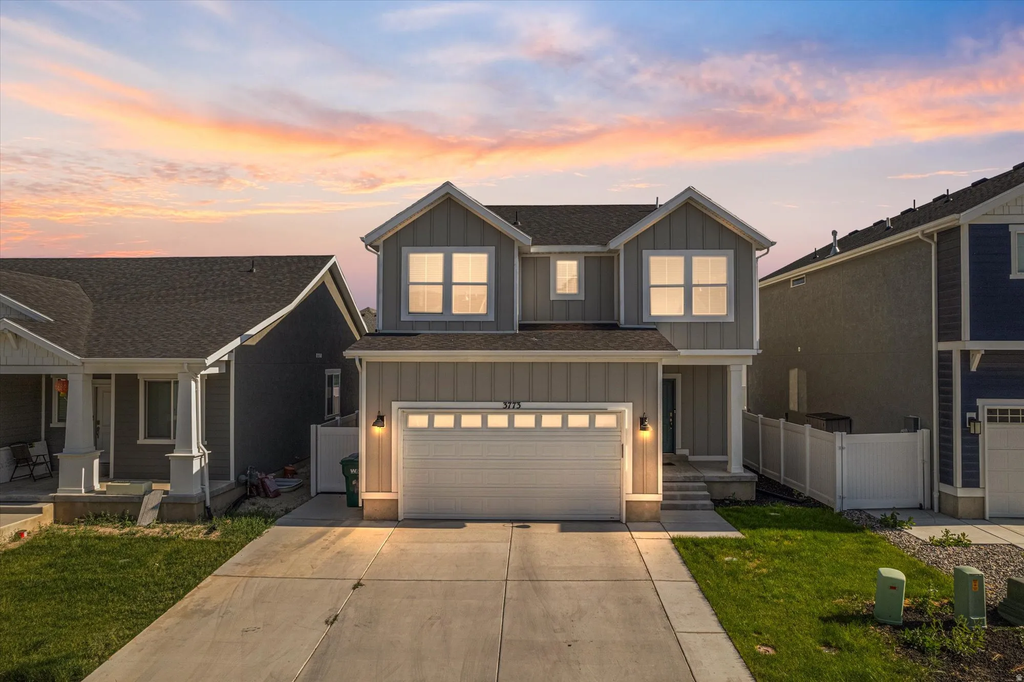 View of front facade featuring board and batten siding, a garage, and driveway