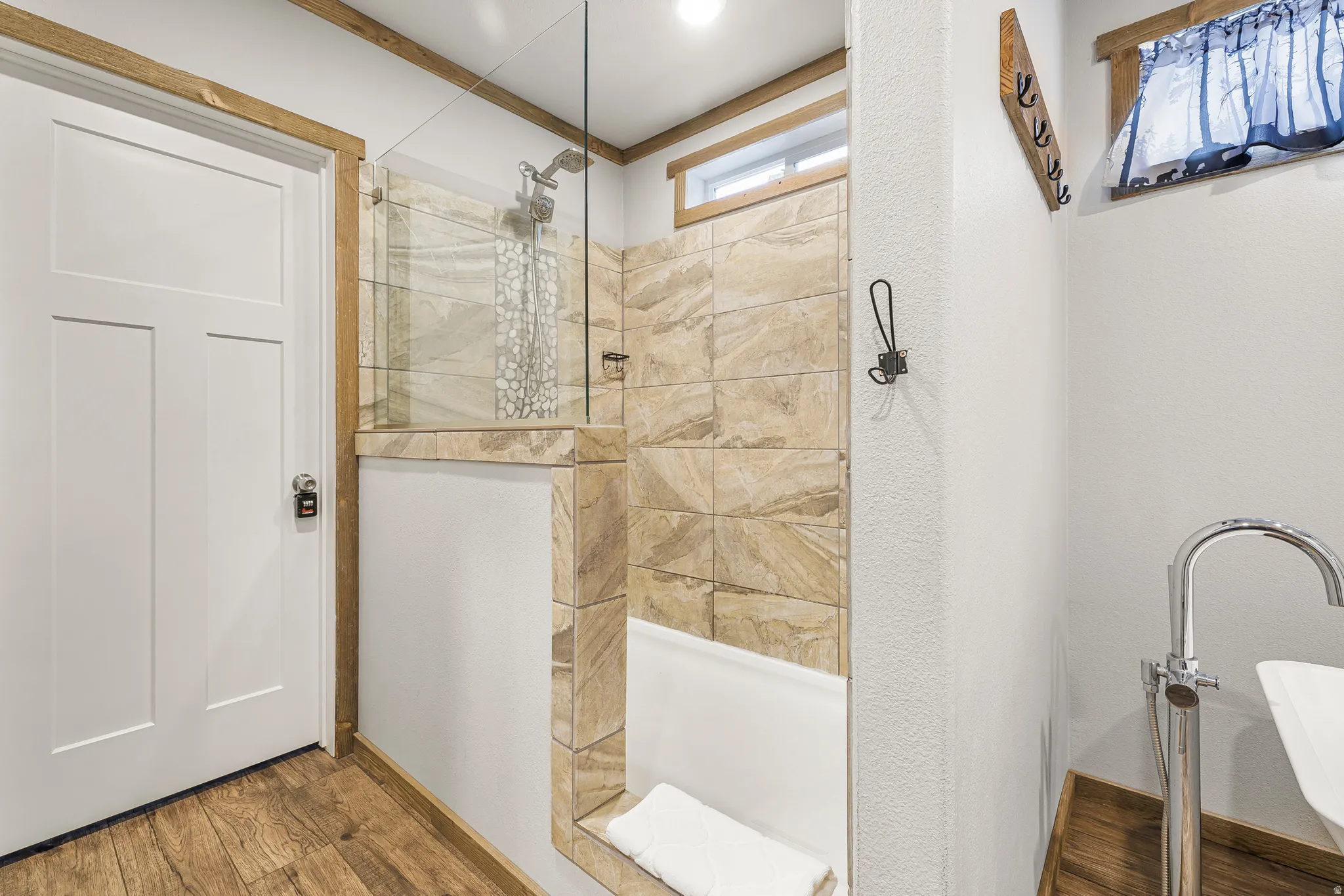 Full bath with a walk in shower and wood finished floors