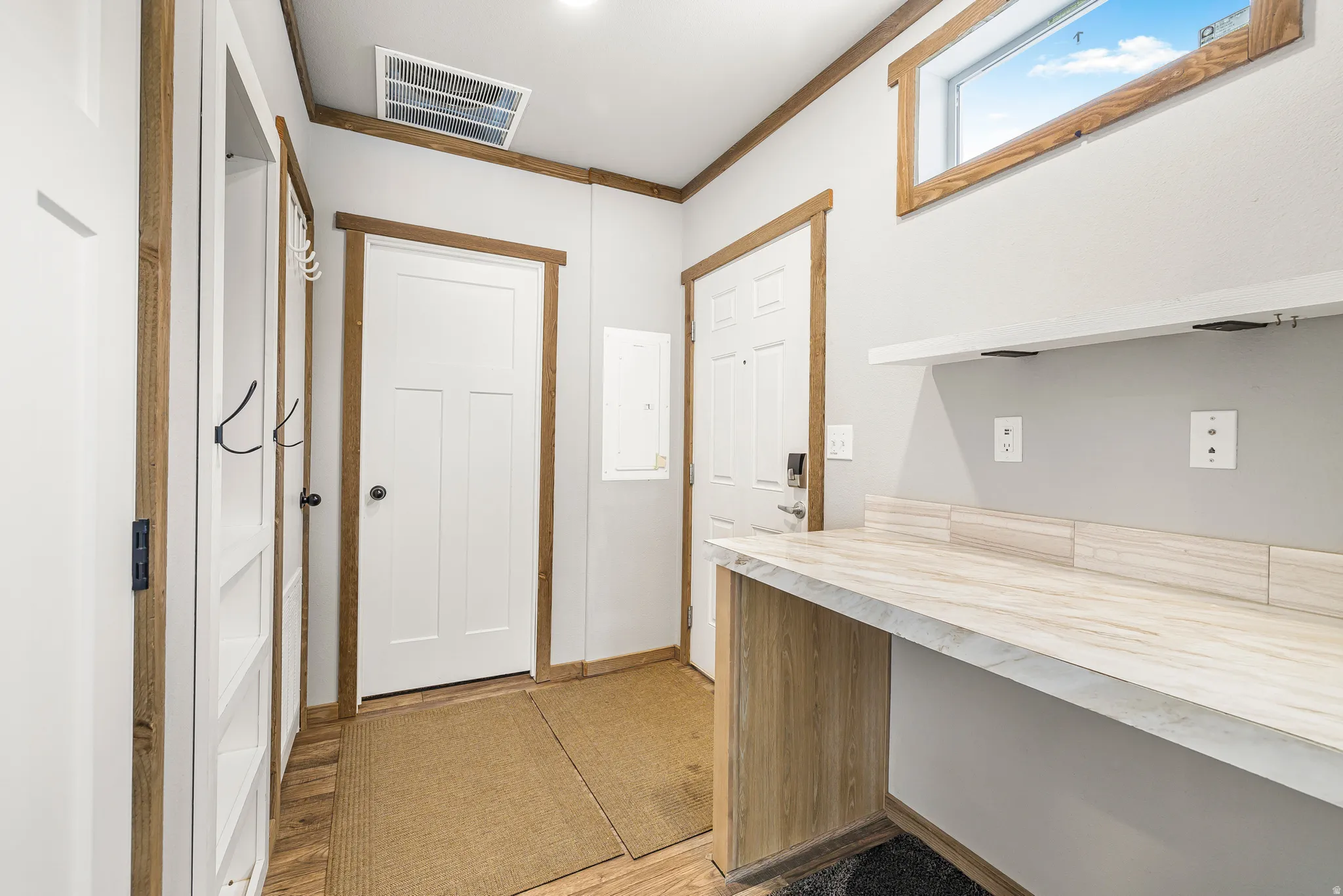 Doorway with wood finished floors and baseboards