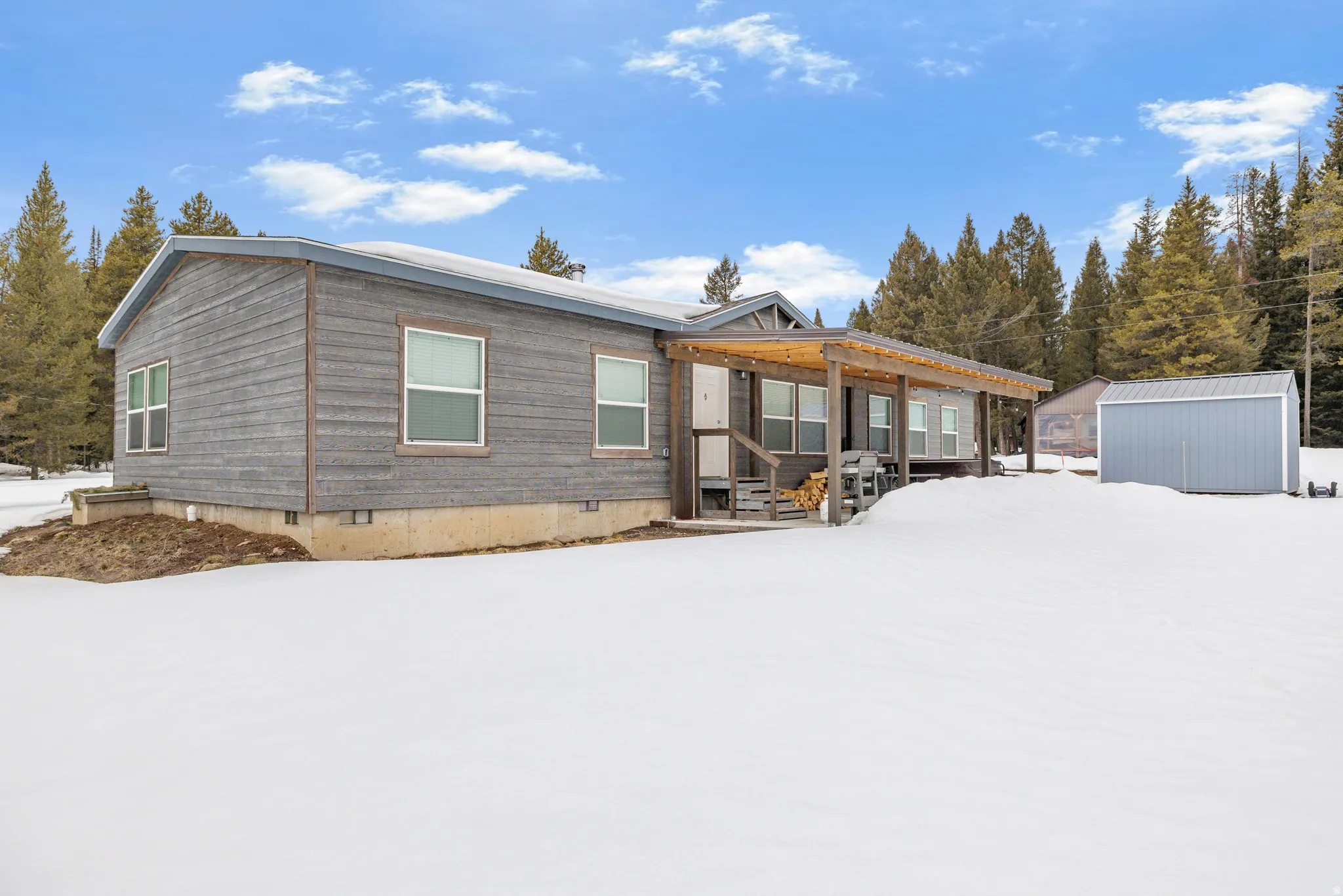 View of front of house with crawl space and an outdoor structure