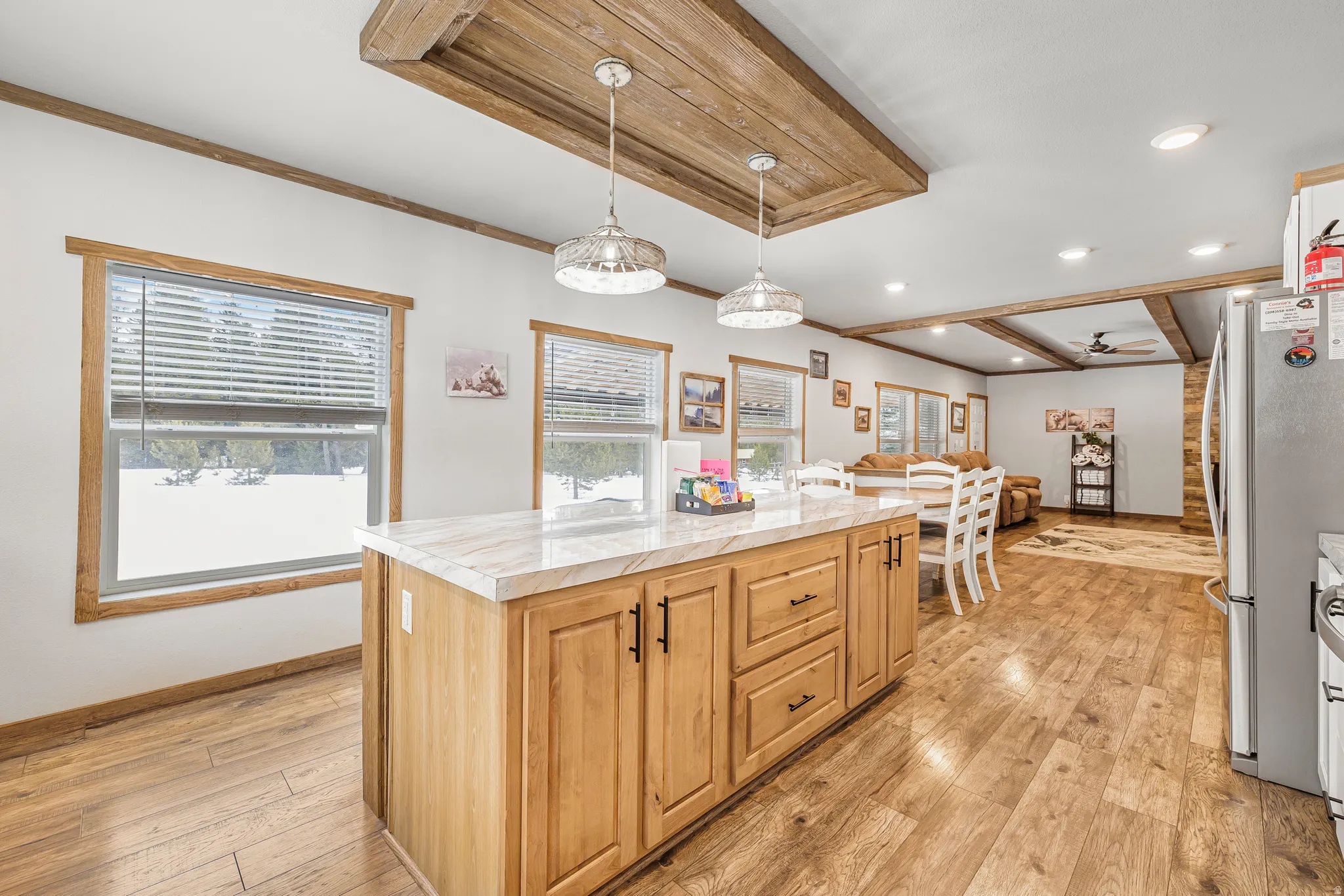 Kitchen featuring light countertops, a center island, light wood finished floors, freestanding refrigerator, and ornamental molding