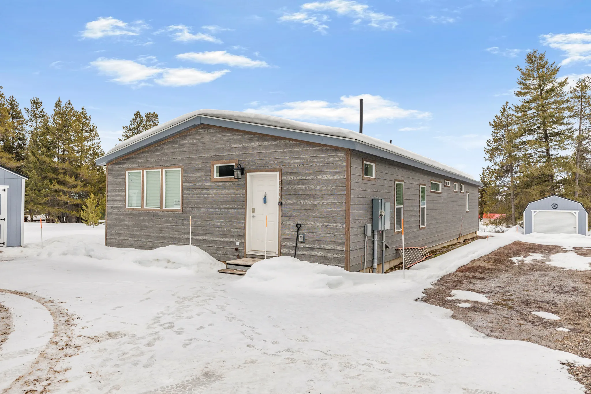 Snow covered property featuring an outdoor structure and a garage
