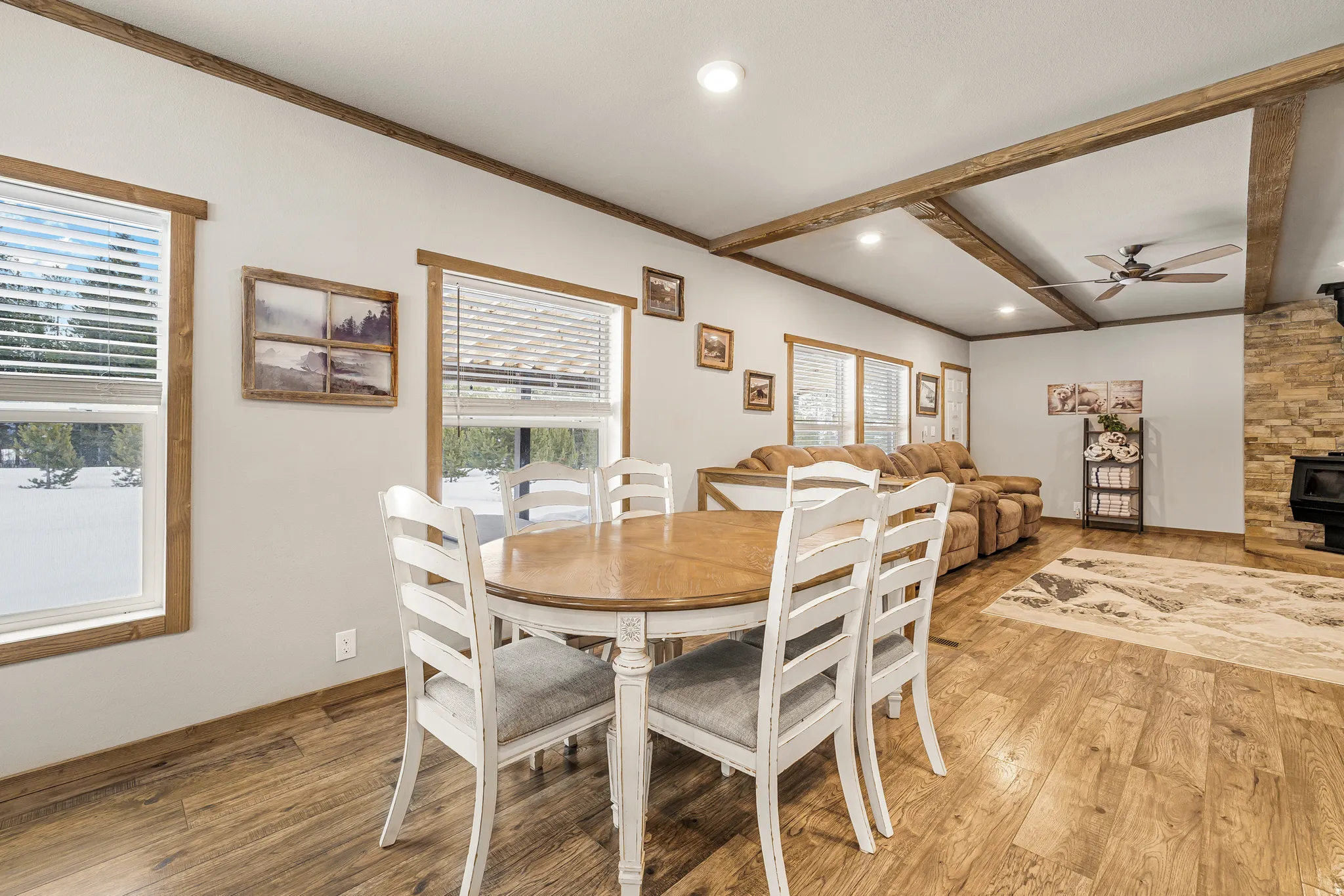 Dining space with a wood stove, ceiling fan, wood finished floors, crown molding, and recessed lighting