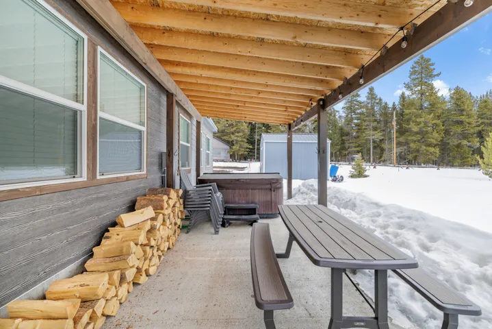 Snow covered patio with a hot tub and a patio