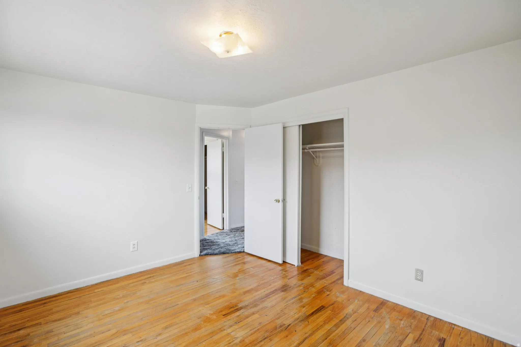 Unfurnished bedroom with light wood finished floors and a closet