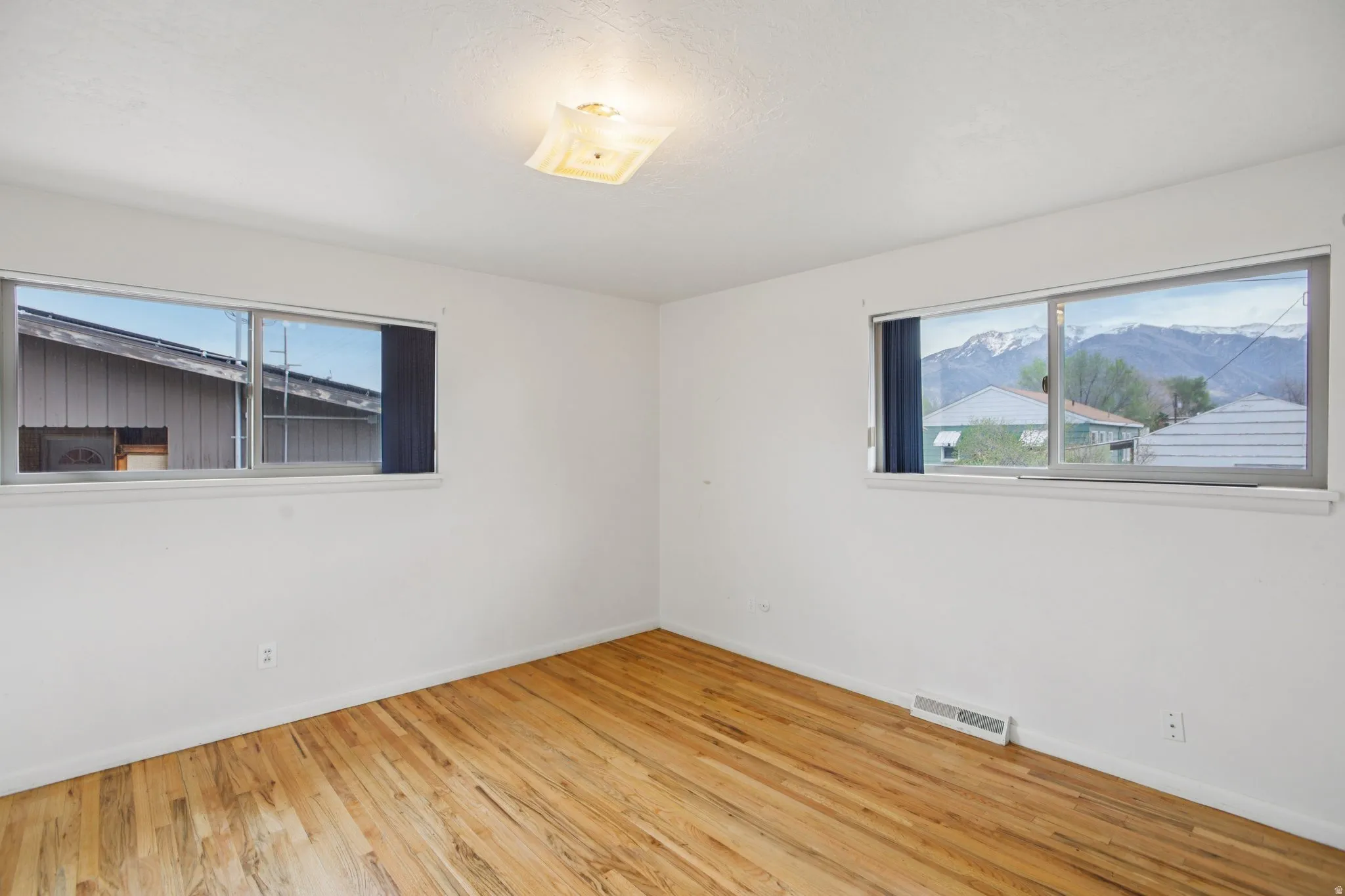 Unfurnished room featuring light wood-style floors and baseboards