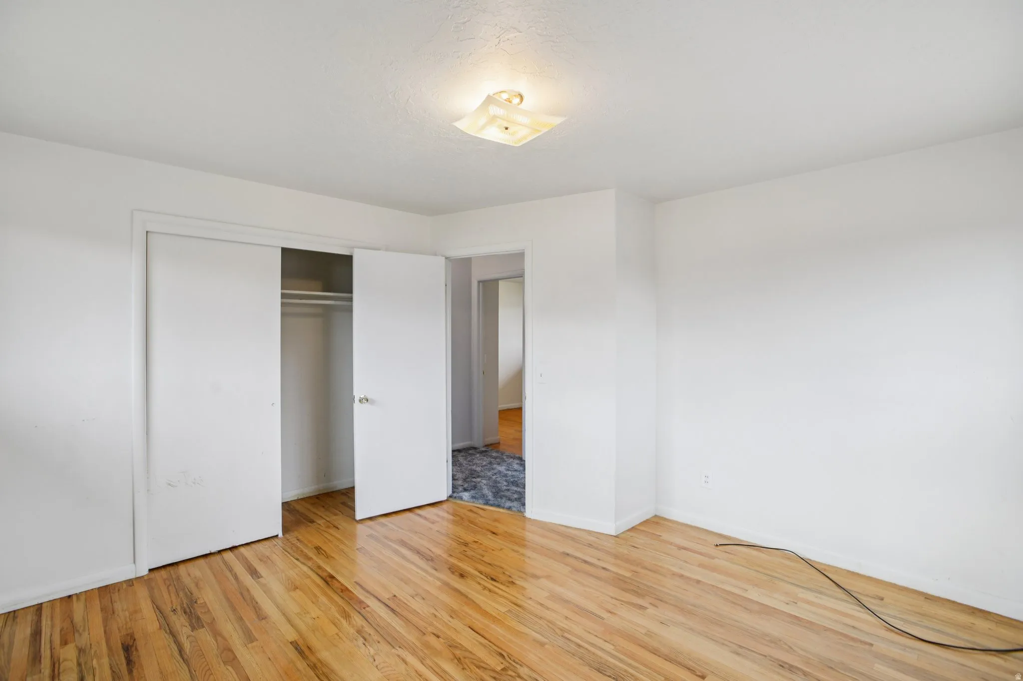 Unfurnished bedroom featuring light wood finished floors and a closet