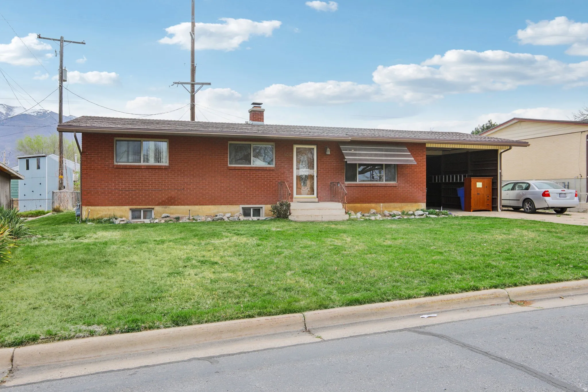 Single story home featuring brick siding, a front yard, and a chimney