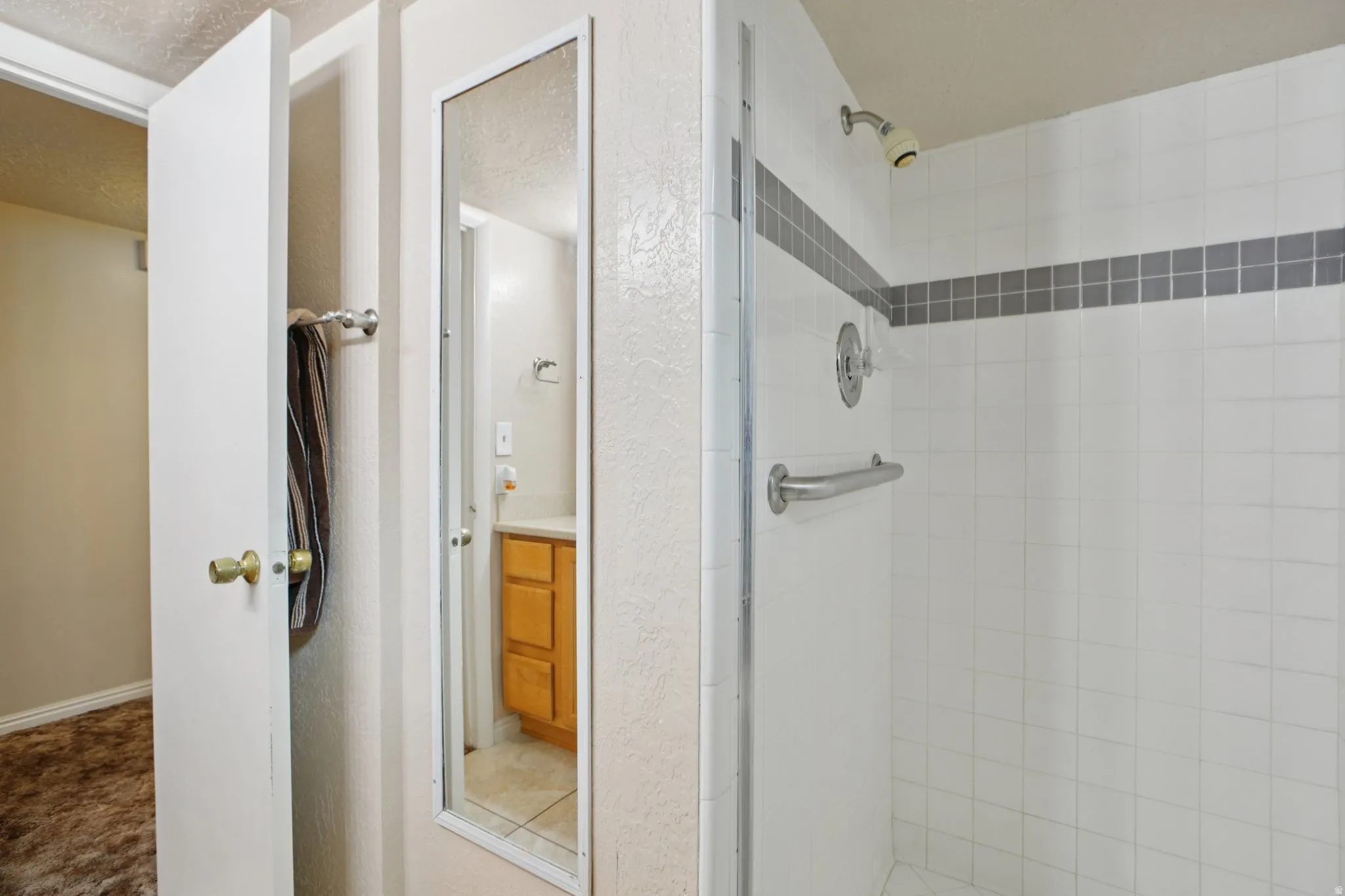 Bathroom featuring a stall shower, vanity, and a textured ceiling