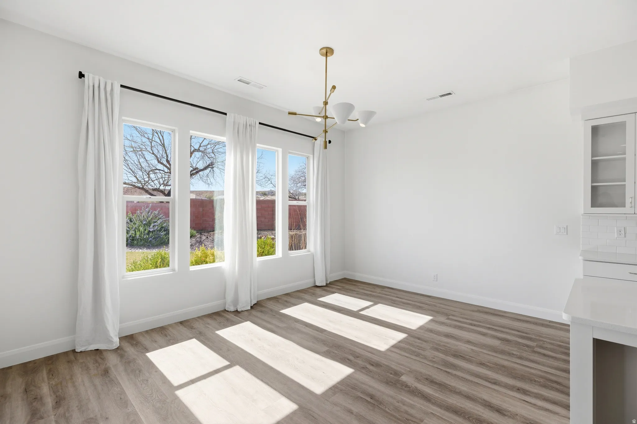Unfurnished dining area with a chandelier and light wood-type flooring