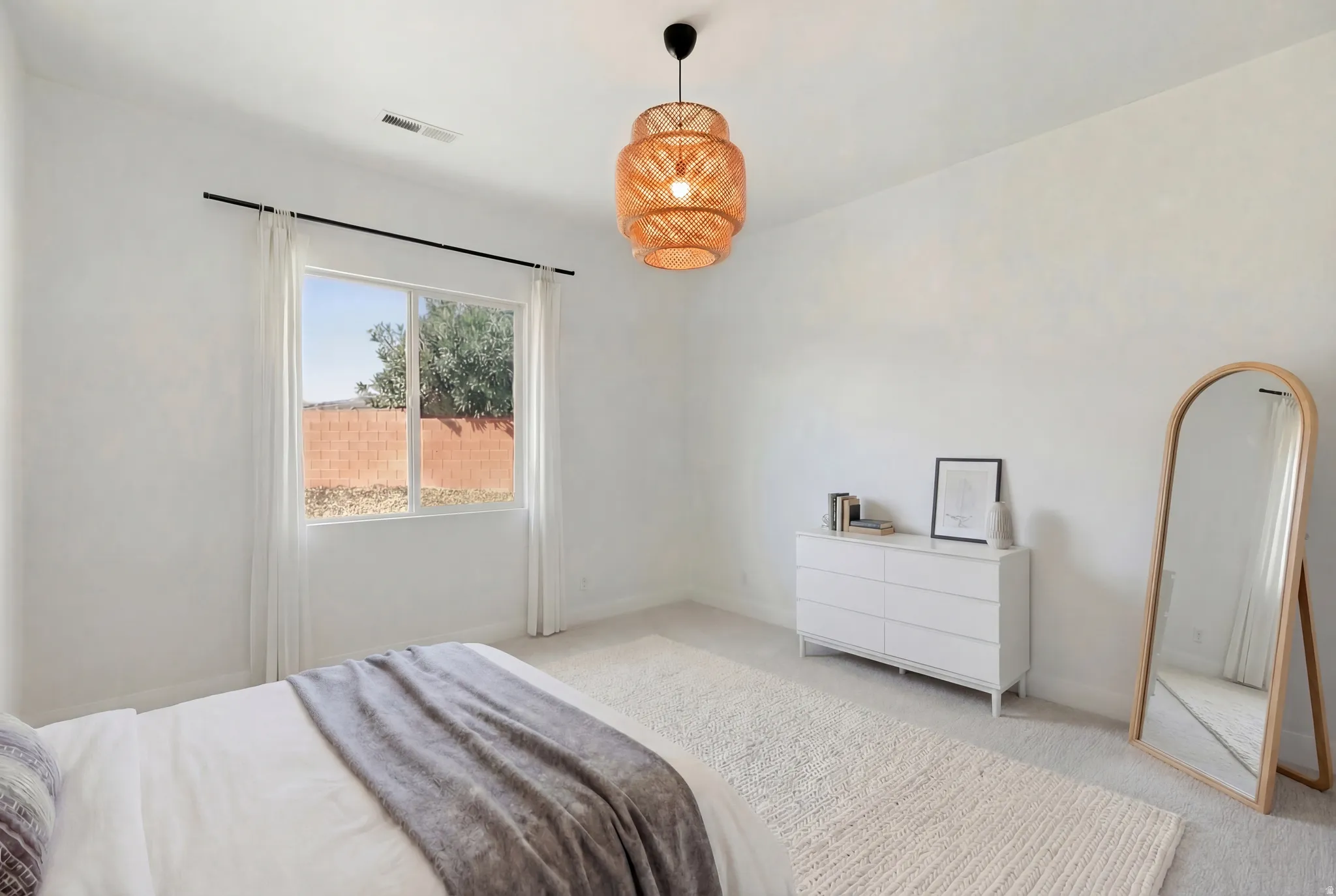 Bedroom featuring light carpet and baseboards